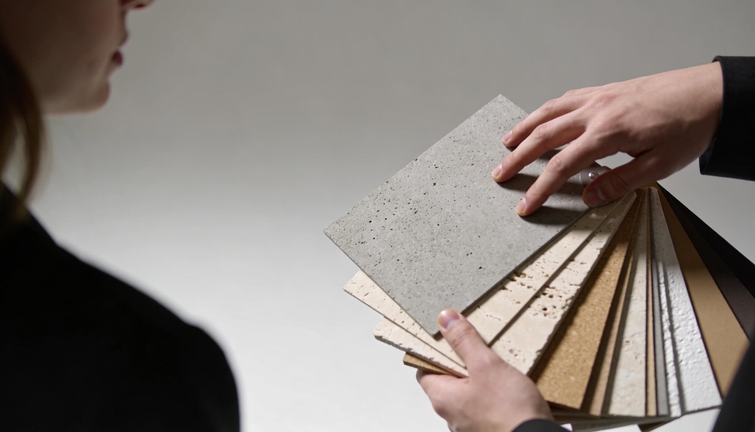 Decorative plaster sample boards compared by hand in studio light